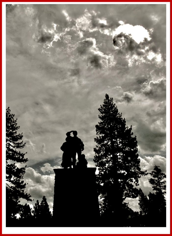 Silhouetted Donner Party Monument beneath dramatic clouds and sunlight